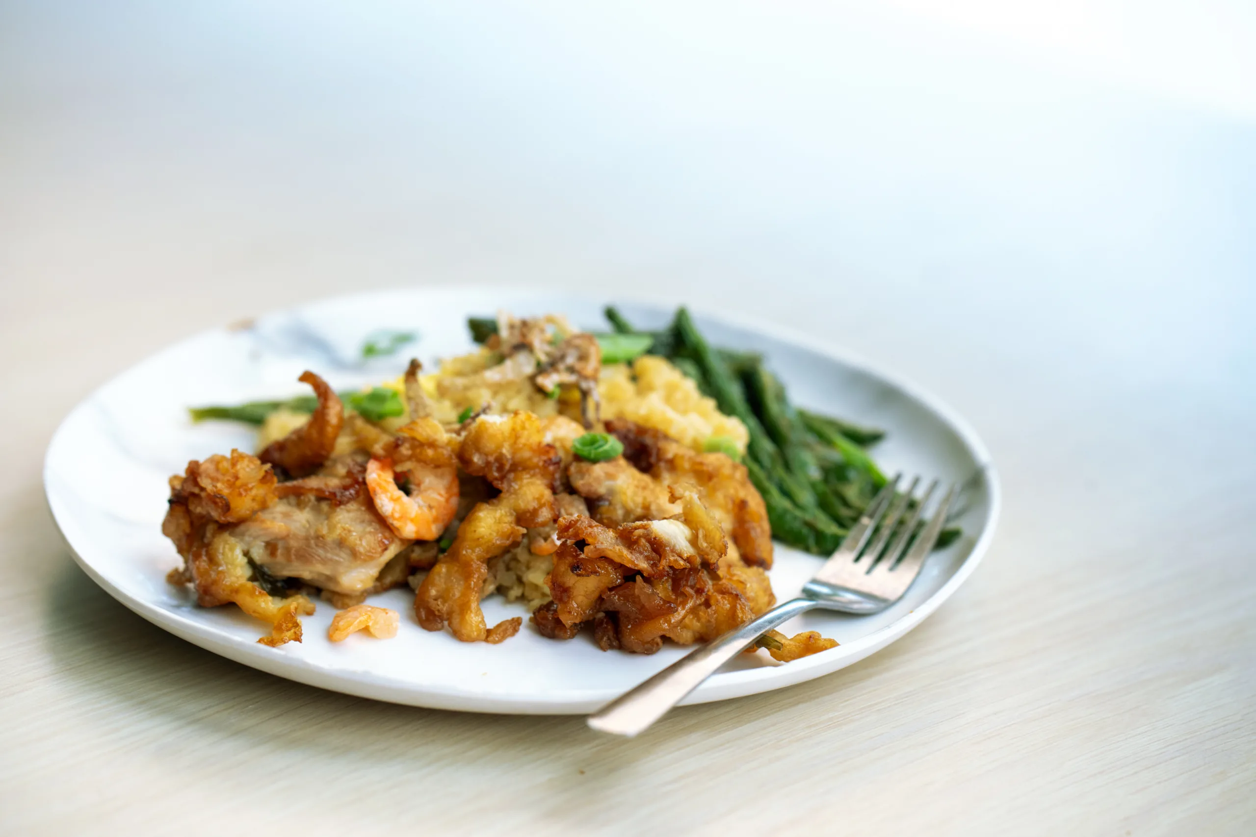A plate displayed a meal prepared by Chef Tila and his original recipes, including fried rice, sautéed green beans, and orange chicken.
