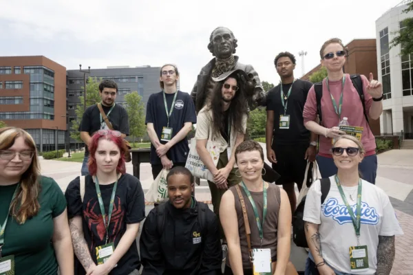 A group of incoming students posed in front of the George Mason statue.