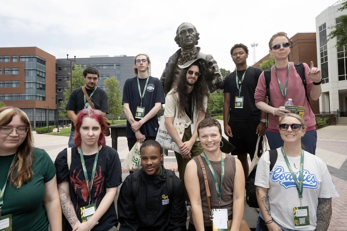 A group of incoming students posed in front of the George Mason statue.