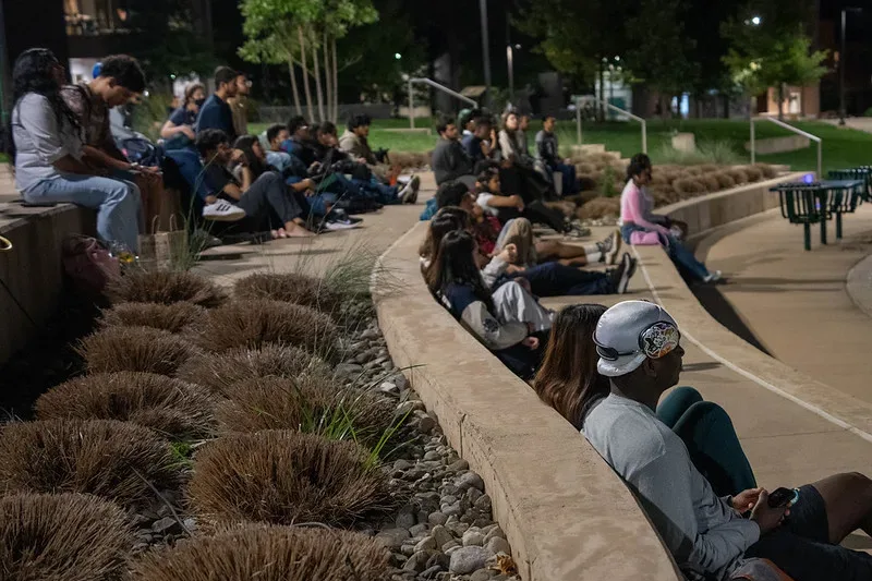 Students gathered around the meditation garden for a night showing.