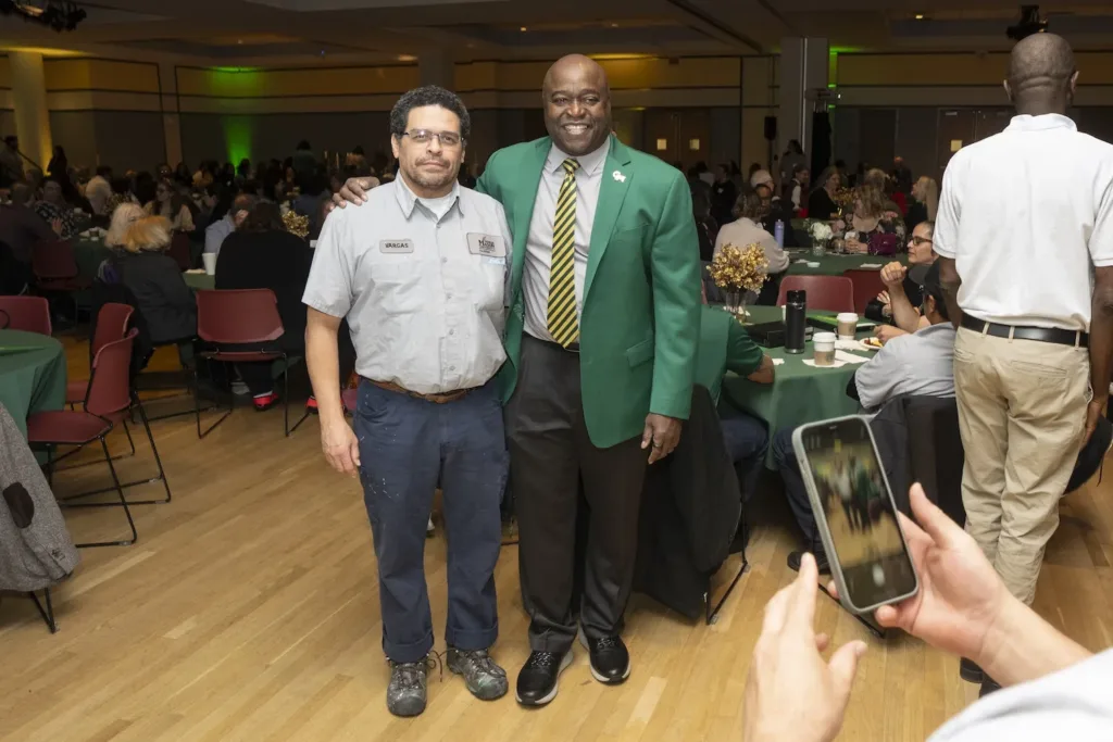 President Gregory Washington celebrates faculty and staff at the University Day Service Awards 2025 posing for a photo with Jose Vargas, Facilities & Campus Operations.