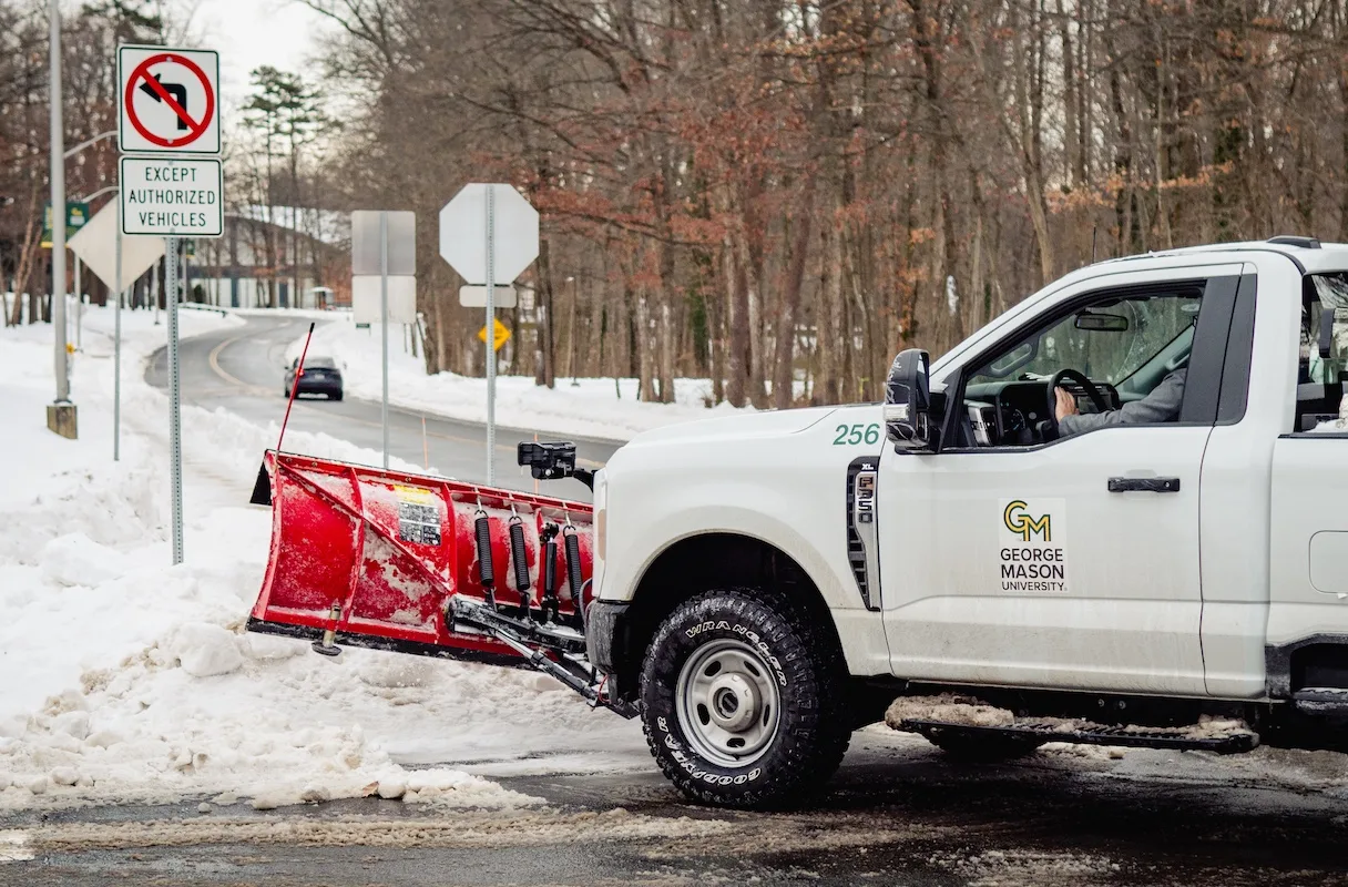 George Mason University gets covered in snow. A plow clears the way.