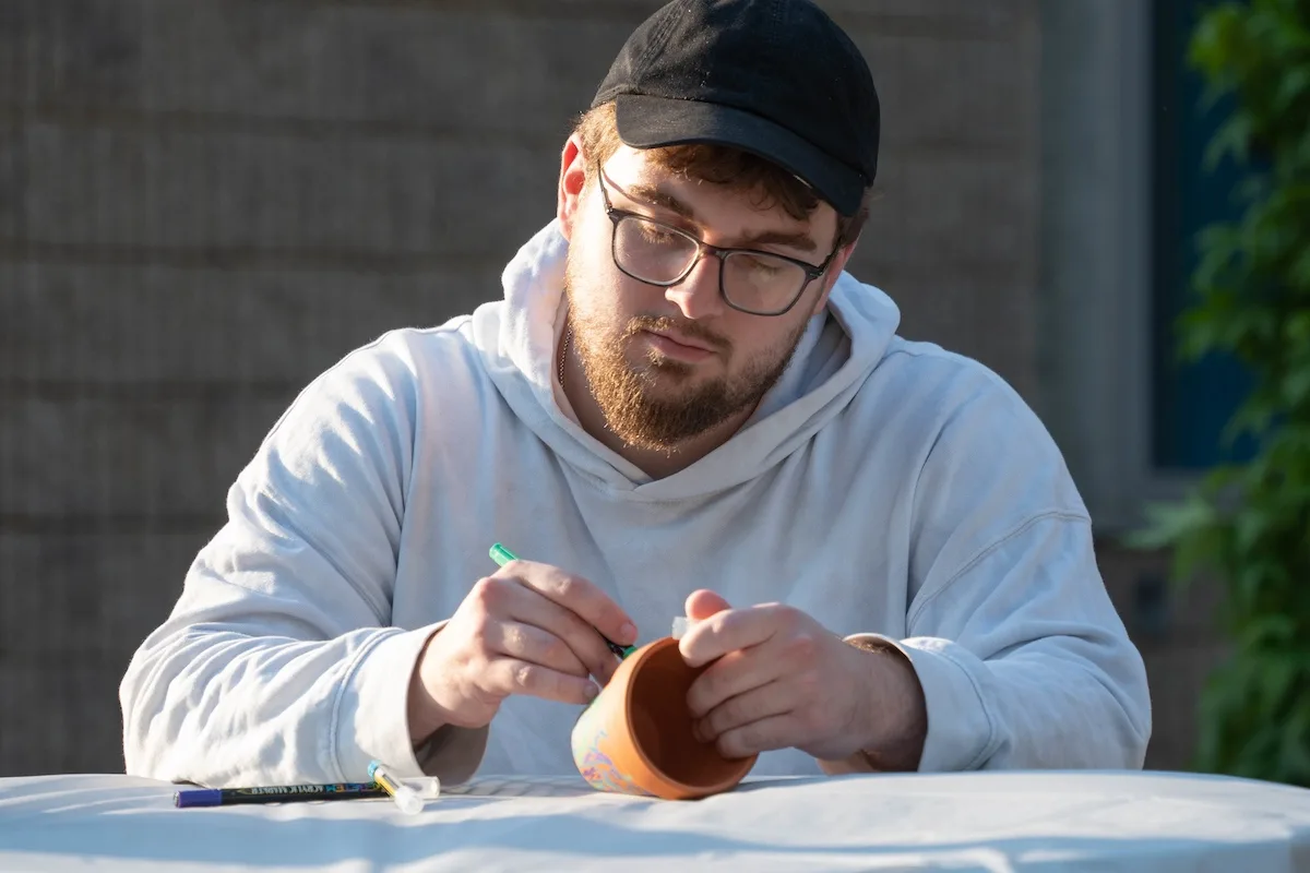 A student carefully painted on a clay pot.