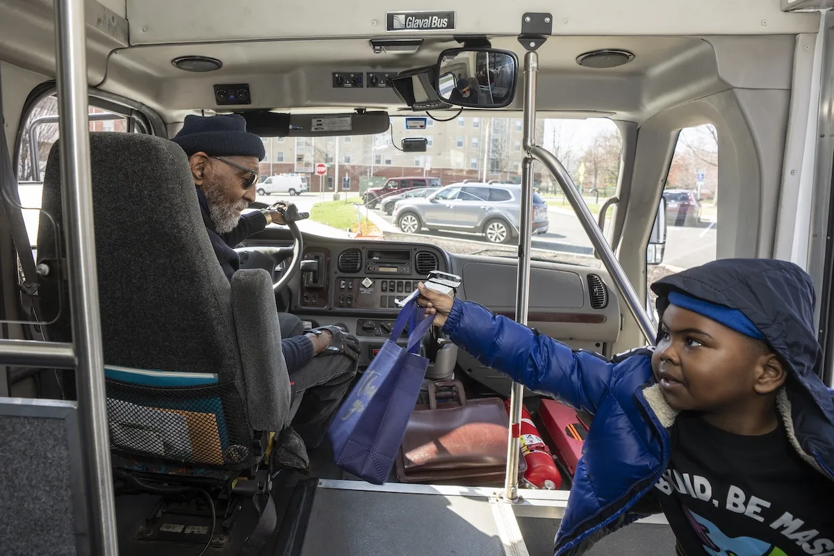 A child handed a goodie bag to a transit driver